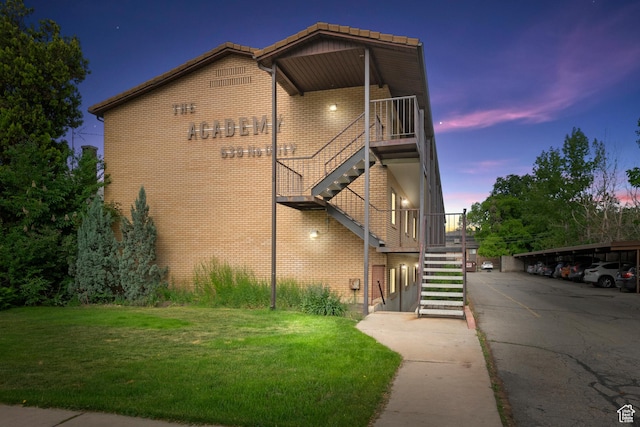 property at dusk with covered parking and stairs