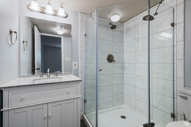 639 N University Ave Unit 2, Provo, UT 84601 - bathroom featuring vanity, a textured ceiling, a stall shower, and toilet