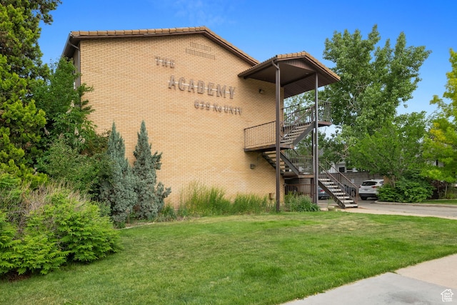 639 N University Ave Unit 2, Provo, UT 84601 - view of property exterior featuring stairs, a yard, brick siding, and a tiled roof
