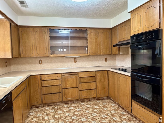 56 S 700 E, Hyrum, UT 84319 - kitchen featuring black appliances, brown cabinetry, under cabinet range hood, a textured ceiling, and light countertops