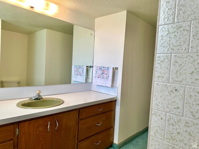 56 S 700 E, Hyrum, UT 84319 - bathroom featuring vanity, toilet, a textured ceiling, and baseboards