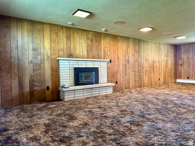 56 S 700 E, Hyrum, UT 84319 - unfurnished living room with carpet floors, a tiled fireplace, a textured ceiling, wooden walls, and baseboard heating