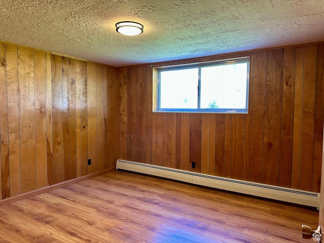 56 S 700 E, Hyrum, UT 84319 - empty room featuring baseboard heating, wood finished floors, a textured ceiling, and wooden walls