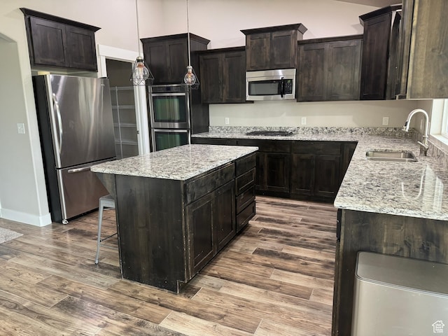 1350 S 849 W Unit 17D, Springville, UT 84663 - kitchen featuring appliances with stainless steel finishes, a sink, dark wood-type flooring, a center island, and light stone countertops