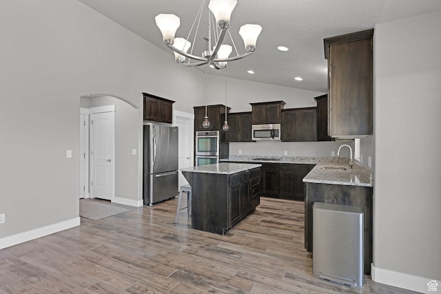 1350 S 849 W Unit 17D, Springville, UT 84663 - kitchen with appliances with stainless steel finishes, a sink, a center island, dark brown cabinets, and arched walkways