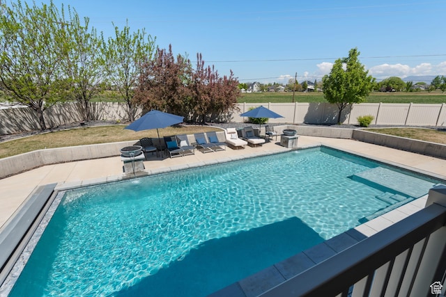 view of swimming pool with a fenced in pool, a fenced backyard, and a patio area