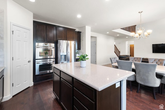 kitchen with dark wood-type flooring, open floor plan, dark brown cabinetry, and stainless steel appliances