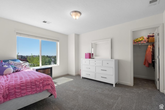 carpeted bedroom featuring visible vents, baseboards, and a spacious closet