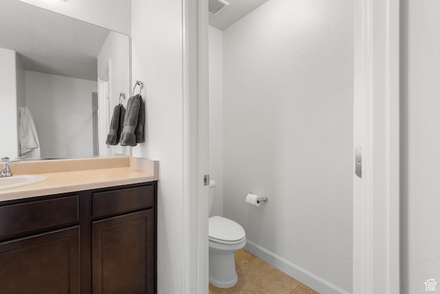 bathroom with visible vents, tile patterned flooring, vanity, baseboards, and toilet
