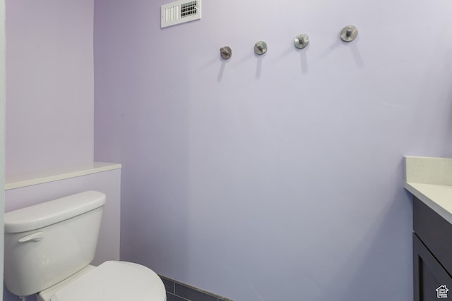 bathroom featuring vanity, toilet, and visible vents