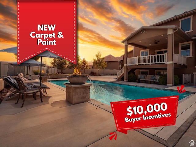 pool at dusk featuring stairway, ceiling fan, a fenced in pool, and a fenced backyard