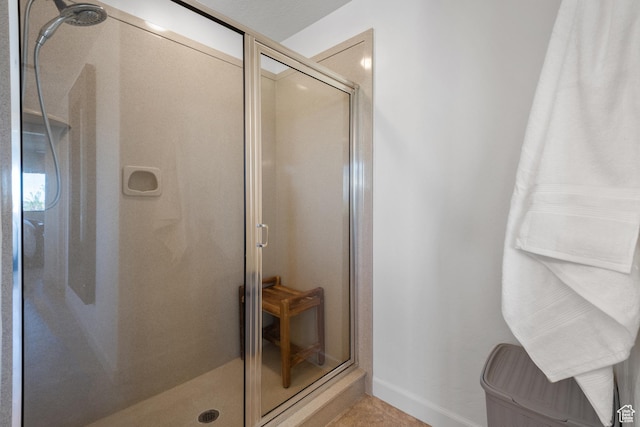 full bathroom featuring baseboards and a shower stall