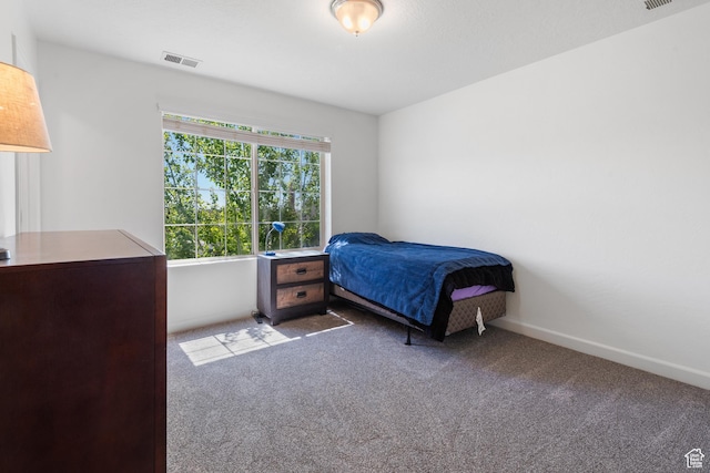 carpeted bedroom with visible vents and baseboards