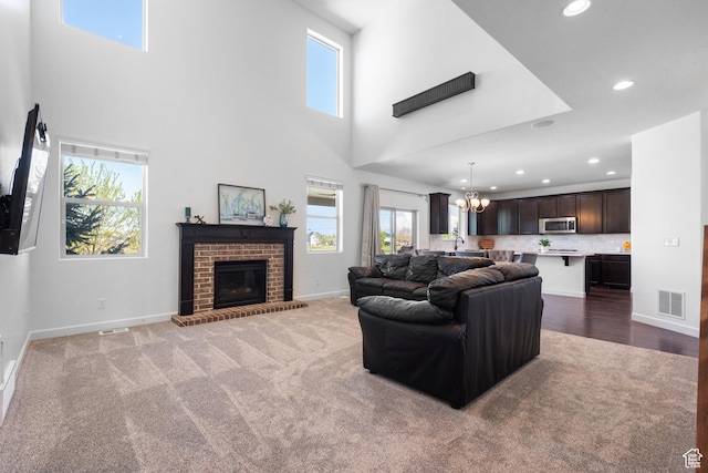 living room with visible vents, an inviting chandelier, baseboards, recessed lighting, and carpet