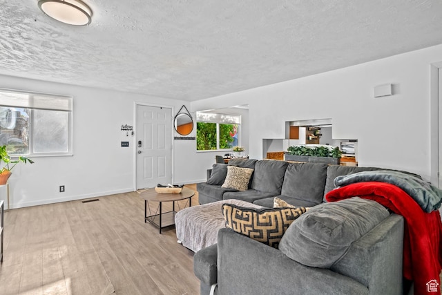 1167 W 4300 S Unit 27C, Taylorsville, UT 84123 - living area featuring baseboards, light wood-type flooring, a textured ceiling, and visible vents