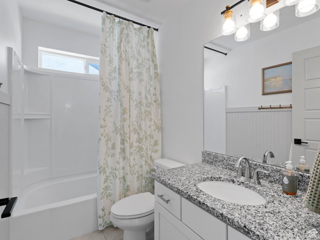 full bathroom featuring tile patterned flooring, wainscoting, vanity, toilet, and shower / bath combo with shower curtain