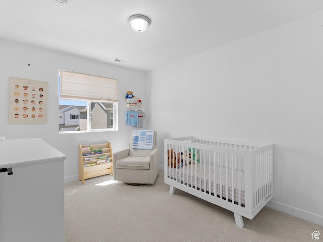 bedroom with baseboards, visible vents, carpet flooring, and a crib