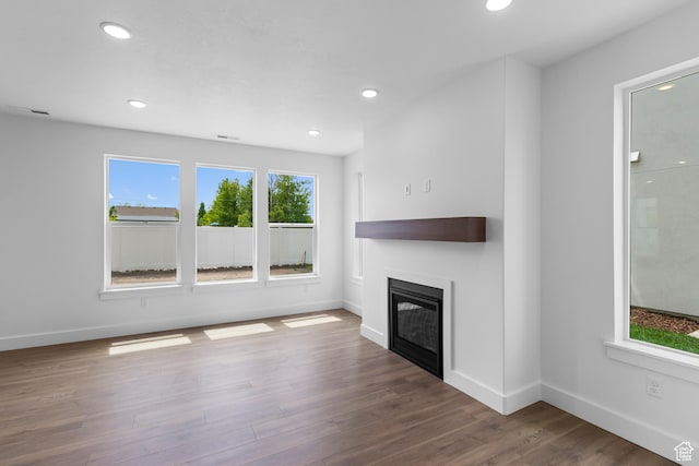 688 N 600 W Unit 104, Tremonton, UT 84337 - unfurnished living room featuring a glass covered fireplace, wood finished floors, and recessed lighting