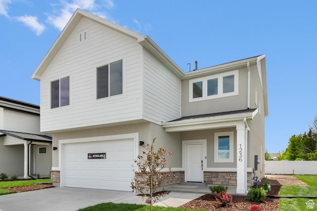 688 N 600 W Unit 104, Tremonton, UT 84337 - view of front of house featuring stone siding, stucco siding, an attached garage, and concrete driveway