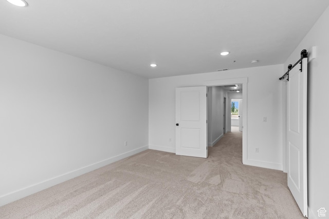 688 N 600 W Unit 104, Tremonton, UT 84337 - unfurnished bedroom with a barn door, recessed lighting, and light carpet