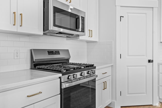 688 N 600 W Unit 104, Tremonton, UT 84337 - kitchen featuring stainless steel appliances, white cabinets, backsplash, and light countertops