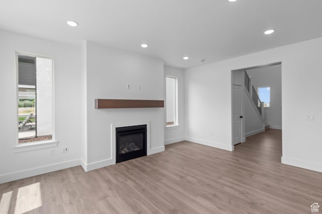 688 N 600 W Unit 104, Tremonton, UT 84337 - unfurnished living room with light wood-style floors, recessed lighting, and a glass covered fireplace
