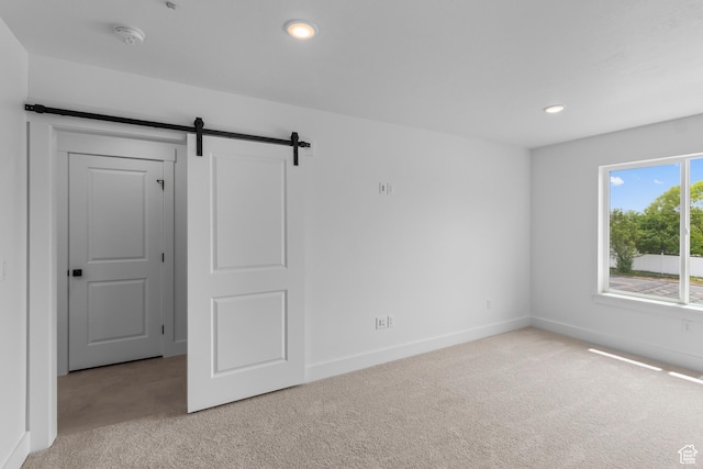 688 N 600 W Unit 104, Tremonton, UT 84337 - spare room featuring light colored carpet, a barn door, recessed lighting, and a smoke detector