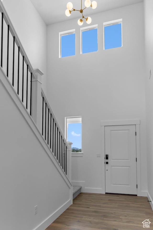 688 N 600 W Unit 104, Tremonton, UT 84337 - entrance foyer featuring stairway, a high ceiling, plenty of natural light, a chandelier, and wood finished floors