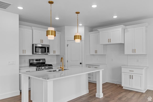 688 N 600 W Unit 104, Tremonton, UT 84337 - kitchen featuring appliances with stainless steel finishes, tasteful backsplash, white cabinets, light countertops, and recessed lighting