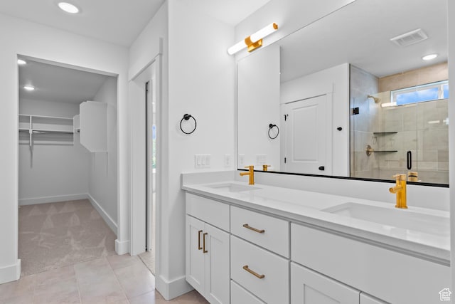 688 N 600 W Unit 104, Tremonton, UT 84337 - bathroom with double vanity, a stall shower, a walk in closet, tile patterned floors, and recessed lighting