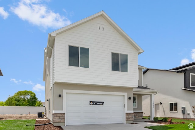 688 N 600 W Unit 104, Tremonton, UT 84337 - view of front of home featuring stone siding, an attached garage, driveway, and stucco siding