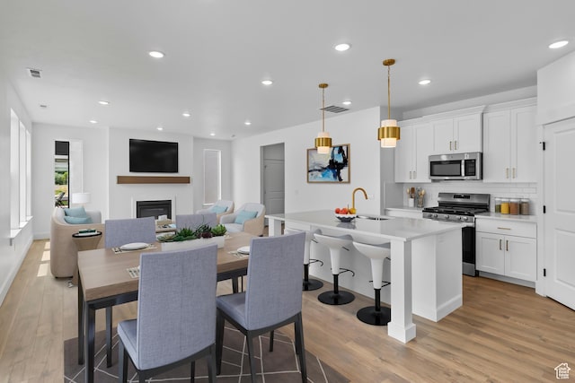 688 N 600 W Unit 104, Tremonton, UT 84337 - dining area featuring light wood-type flooring, a glass covered fireplace, and recessed lighting
