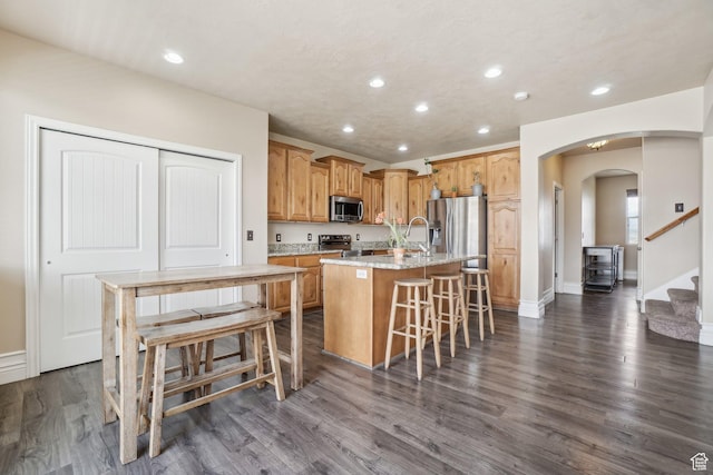 3214 W Ridgeline Rd, Stockton, UT 84071 - kitchen with recessed lighting, arched walkways, an island with sink, and stainless steel appliances