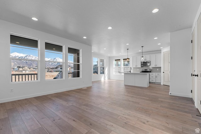 1446 N 3250 W, Provo, UT 84601 - unfurnished living room featuring recessed lighting, baseboards, a sink, and light wood-style floors