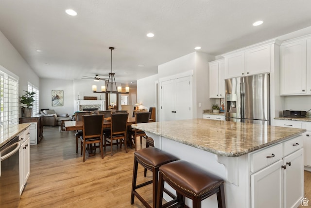 272 S 300 E, Midway, UT 84049 - kitchen featuring appliances with stainless steel finishes, ceiling fan, a fireplace, a kitchen island, and light wood finished floors