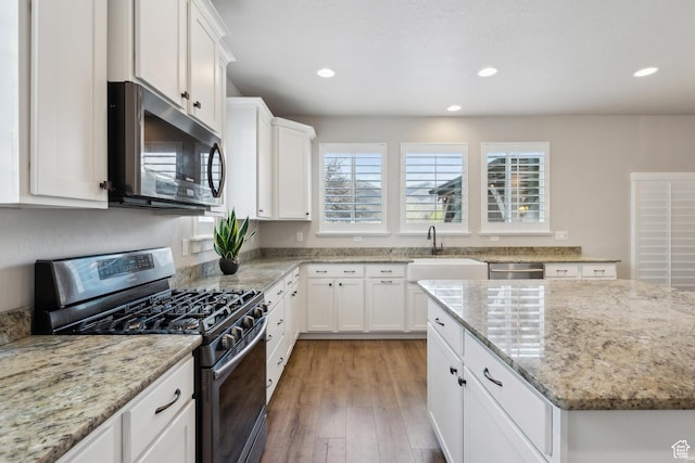 272 S 300 E, Midway, UT 84049 - kitchen with light wood-type flooring, white cabinetry, light stone counters, a sink, and appliances with stainless steel finishes
