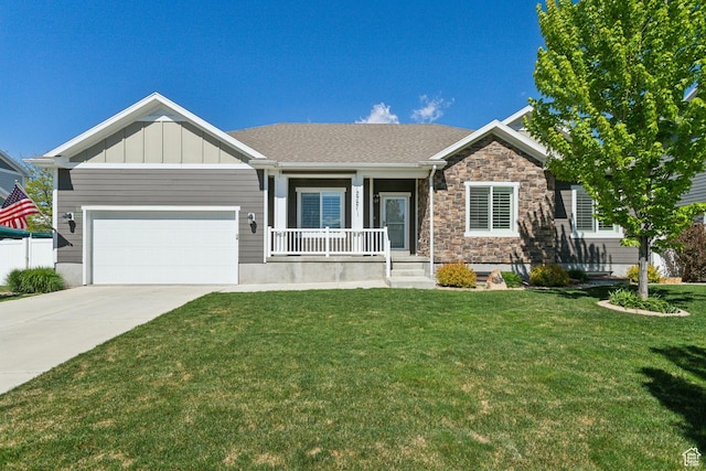 272 S 300 E, Midway, UT 84049 - view of front facade with covered porch, a front yard, concrete driveway, an attached garage, and stone siding