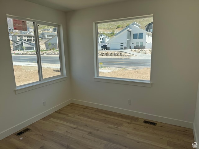 empty room with visible vents, baseboards, and a healthy amount of sunlight