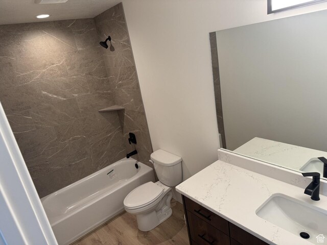 full bath with vanity, shower / bath combination, wood finished floors, and toilet