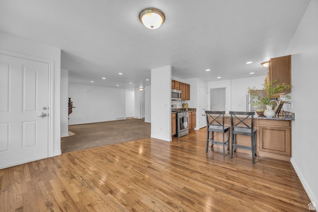 2948 W 150 N, Layton, UT 84041 - kitchen with appliances with stainless steel finishes, brown cabinets, light wood finished floors, dark countertops, and baseboards