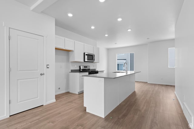 1914 E Thunder Ln N Unit 505, Eagle Mountain, UT 84005 - kitchen featuring visible vents, appliances with stainless steel finishes, a sink, white cabinets, and light wood-style flooring