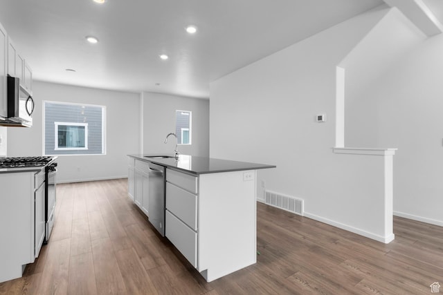1914 E Thunder Ln N Unit 505, Eagle Mountain, UT 84005 - kitchen featuring visible vents, wood finished floors, dark countertops, white cabinetry, and appliances with stainless steel finishes