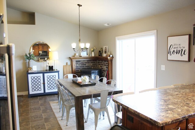 515 S Stump Hollow Rd, Garden City, UT 84028 - dining area with a chandelier, a fireplace, and baseboards