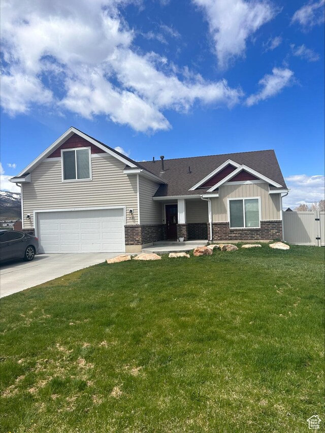 craftsman house featuring an attached garage, a front lawn, fence, and concrete driveway