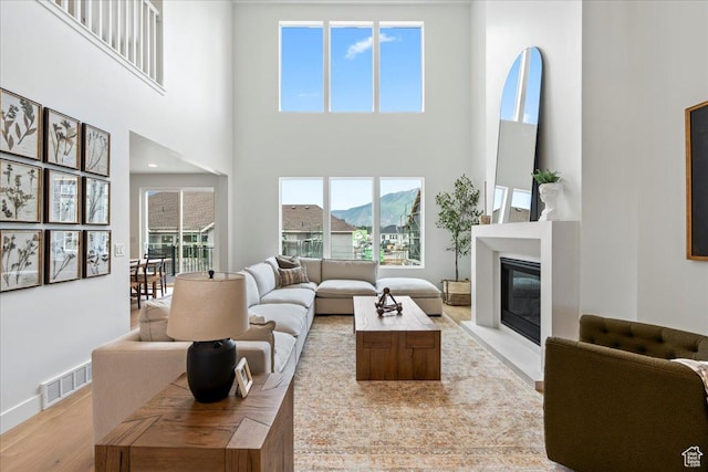 242 W Hillcrest Dr Unit 6, Spanish Fork, UT 84660 - living room with a glass covered fireplace, a towering ceiling, plenty of natural light, and visible vents