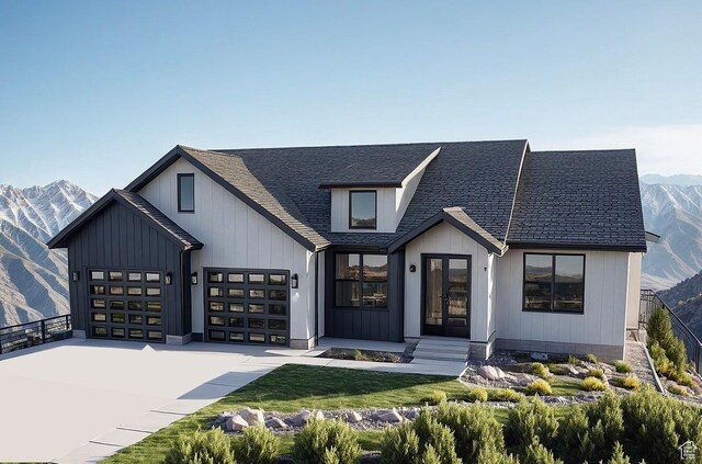 modern farmhouse style home featuring concrete driveway, french doors, a mountain view, and a garage