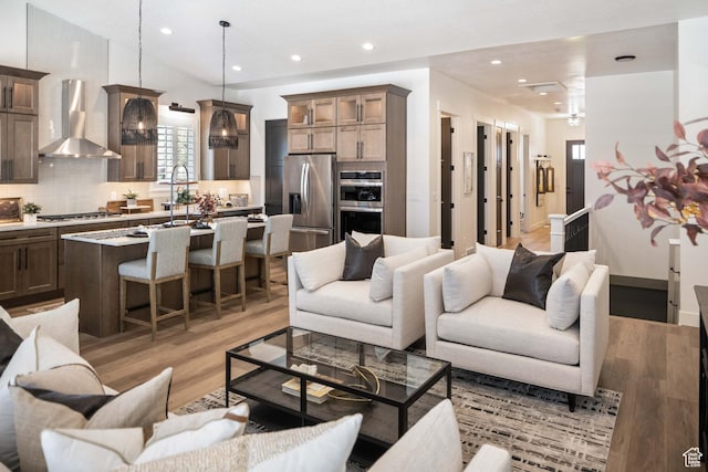 living area featuring recessed lighting, light wood-style flooring, and lofted ceiling