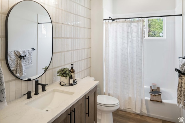 bathroom featuring vanity, toilet, shower / bath combination with curtain, wood finished floors, and tasteful backsplash