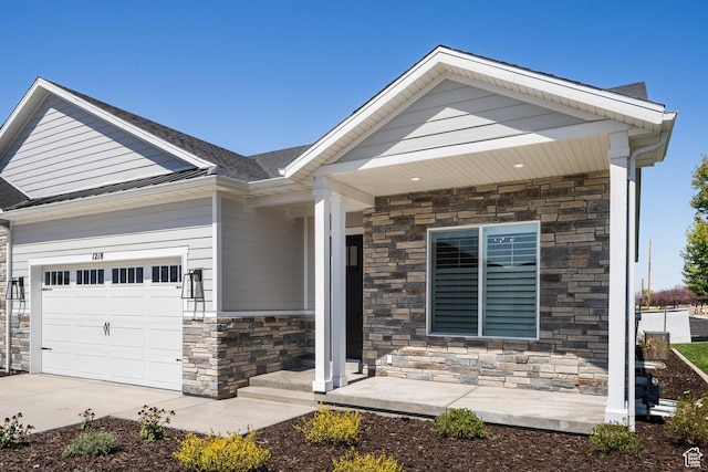craftsman inspired home with an attached garage, driveway, and stone siding