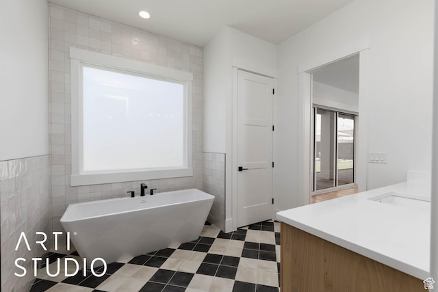 5220 W 2040 S, Hurricane, UT 84737 - full bathroom featuring tile walls, a soaking tub, vanity, and tile patterned flooring